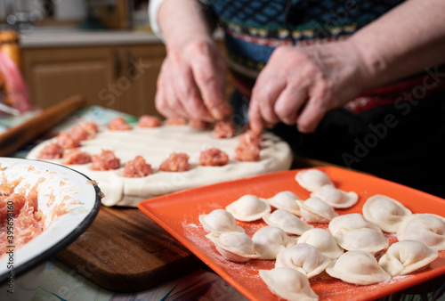 Woman cooking delicious homemade dumplings on the kitchen