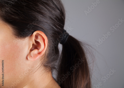 Closeup picture of young woman's ear.