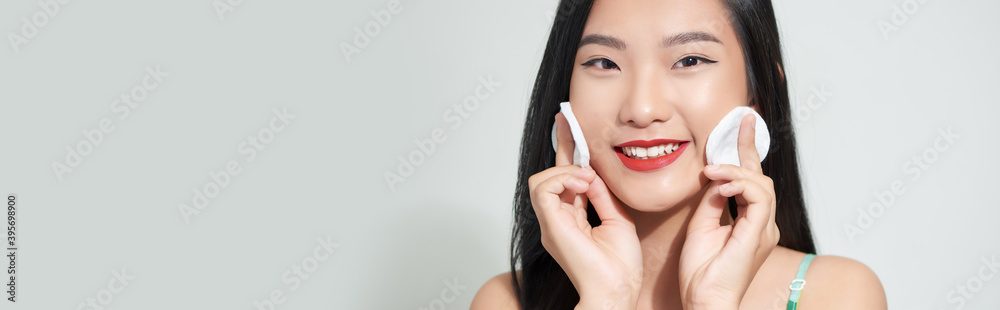 Fototapeta premium Young woman holding sponge in her hands isolated on white background