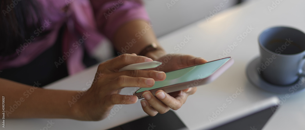 Female hands using smartphone while working in office room