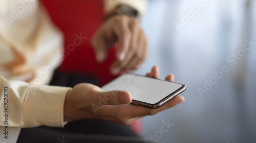 Male hand holding smartphone in blurred background, clipping path