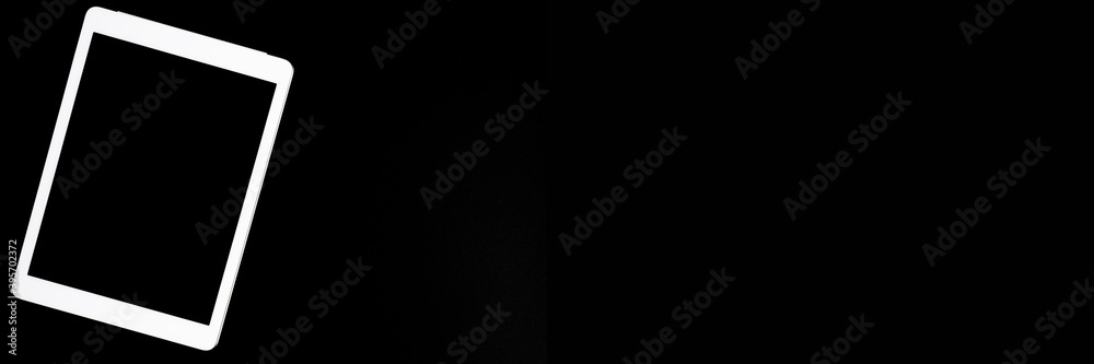 white tablet turned off on a black background. minimal black white concept. space for text. banner