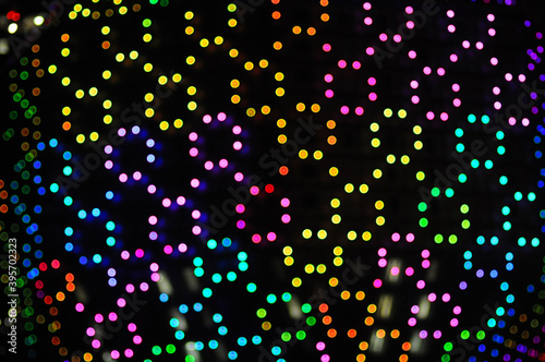 blurred night multi colored glowing lights on black background. new year and christmas concept