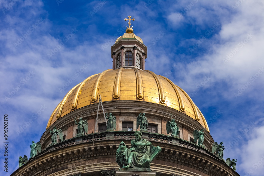 Dome with copper figures on the building of St. Isaac's Cathedral in St. Petersburg Russia against the sky with clouds