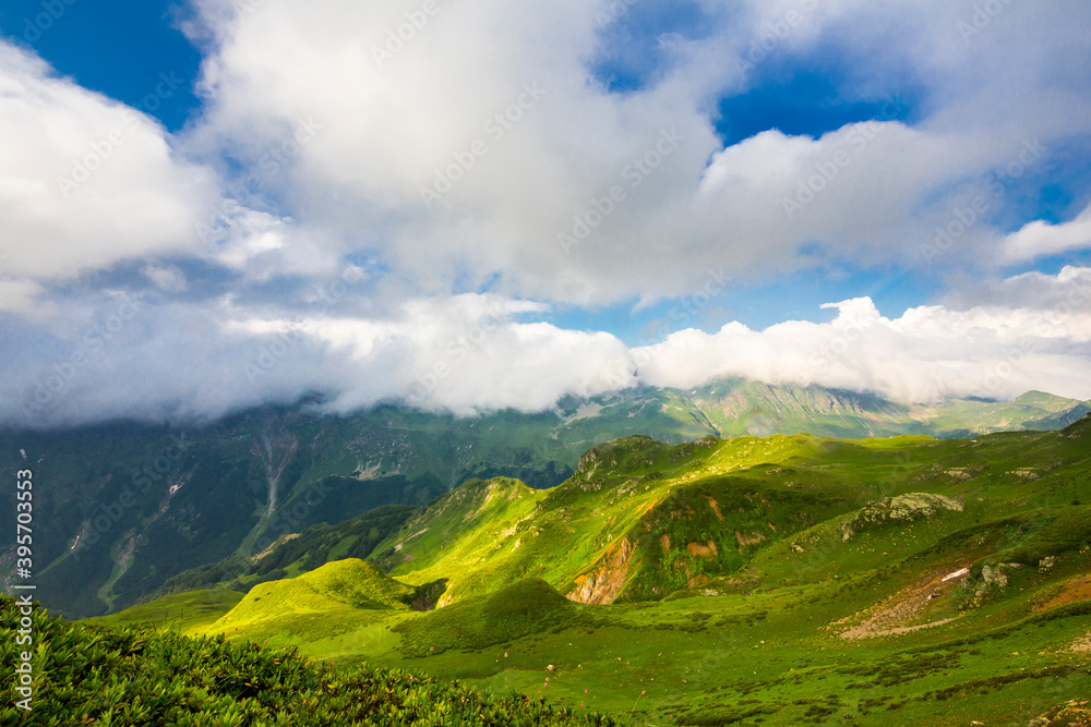 Beautiful mountain landscape at Caucasus mountains with clouds and blue sky