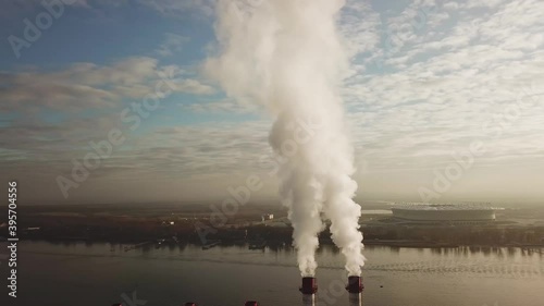 from the boiler room tube goes white steam, smoke into the sky. heating in winter. industrial zone in the city by the river. Cityscape. photo