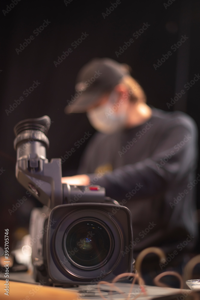 masked cameraman is filming a television show in the studio.