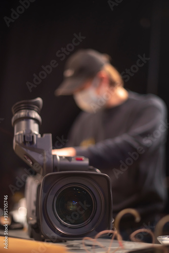 masked cameraman is filming a television show in the studio. © Aliaksei