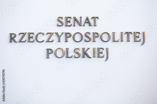 Senat Rzeczypospolitej Polskiej logo herb z flagami Polski i Unii Europejskiej na tle białej ściany
