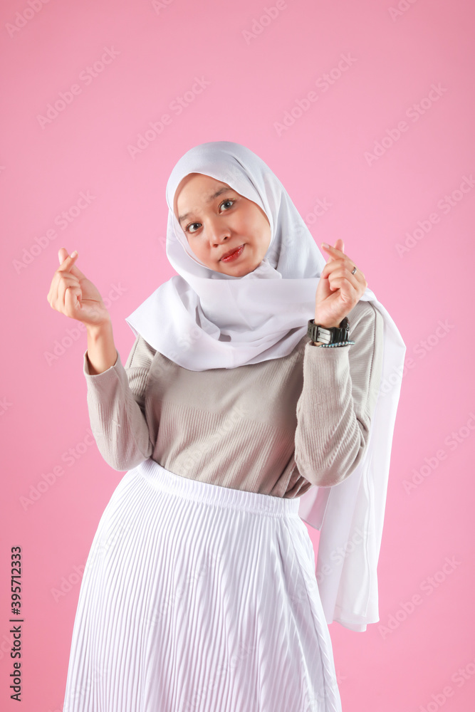 Fashion portrait of young beautiful asian muslim woman with wearing hijab isolated on pink background. Fashion portrait of young beautiful asian muslim woman with wearing hijab isolated on pink background.