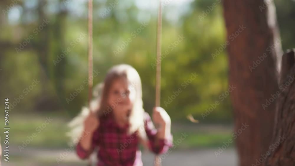 Girl swinging on a rope swing in the forest Girl swinging on a rope swing in the forest