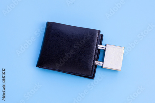 Wallet with padlock on blue background. Copy space
