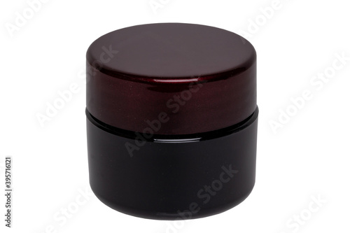 Closeup of a closed cosmetic jar of concealer cream, makeup foundation, moisturising cream for the face or an other beauty or make-up product isolated on a white background.