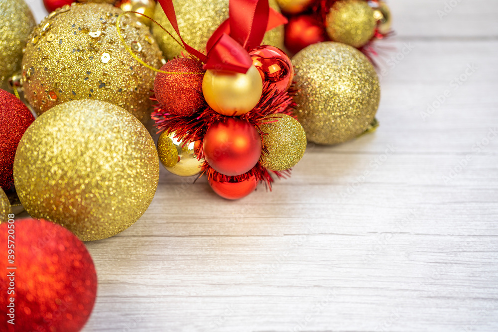 Christmas border of gold and red balls on a white wooden background. New year greeting card Copy space.
