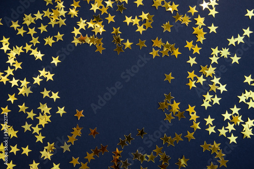 Gold star confetti on a blue background with space for text. Banner, poster.