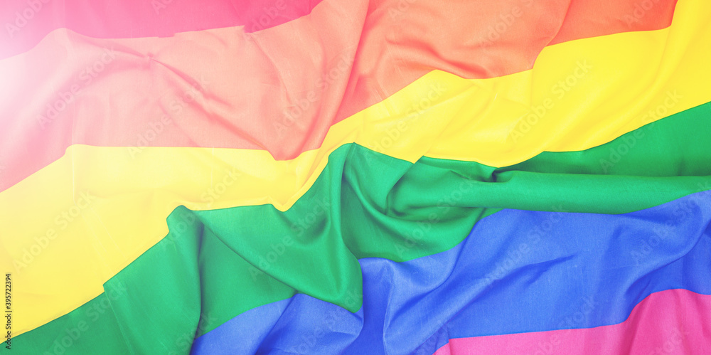 LGBTQ pride creased rainbow flag slightly faded. top view banner or backdrop LGBT background