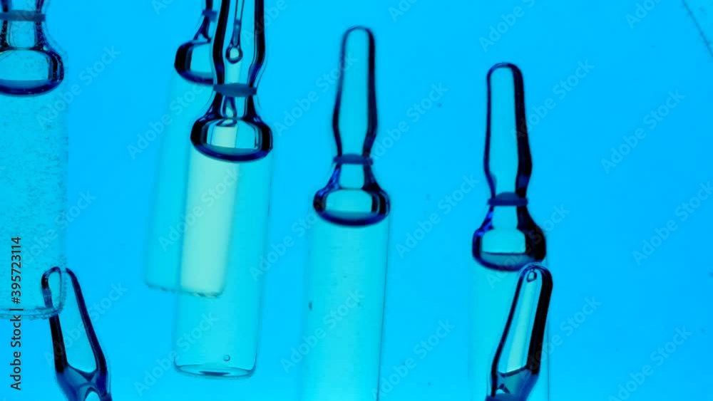 Hyaluronic acid. Cosmetic ampoules.Pharmaceuticals, medicine and cosmetology concept.Medical ampoules in blue water.Health and beauty Hyaluronic acid. Cosmetic ampoules.Pharmaceuticals, medicine and cosmetology concept.Medical ampoules in blue water.Health and beauty