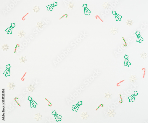 Christmas tree formed clips, Xmas canes, wooden snowflakes on white background. Back to school, Christmas in office concept. Xmas greeting card. Flat lay style with copy space.