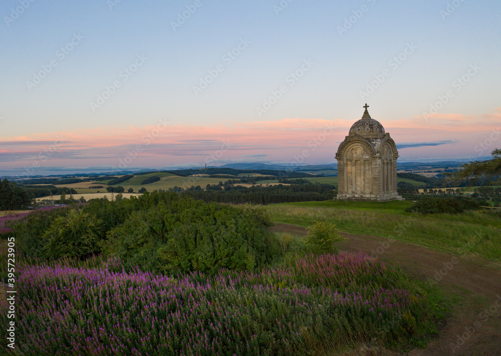 Old mausoleum on a scenic banking with vast landscape and sun setting