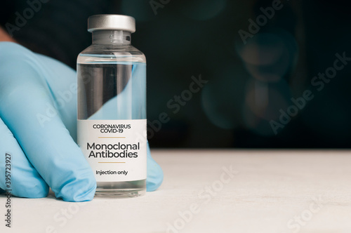 Doctor hold a vial of monoclonal antibodies, a new treatment for coronavirus Covid-19, on a white table