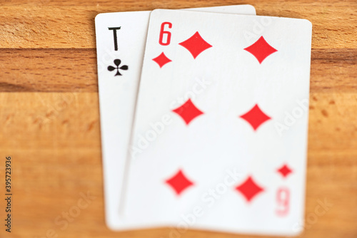 Paper playing cards for playing poker on the background of a wooden brown board.