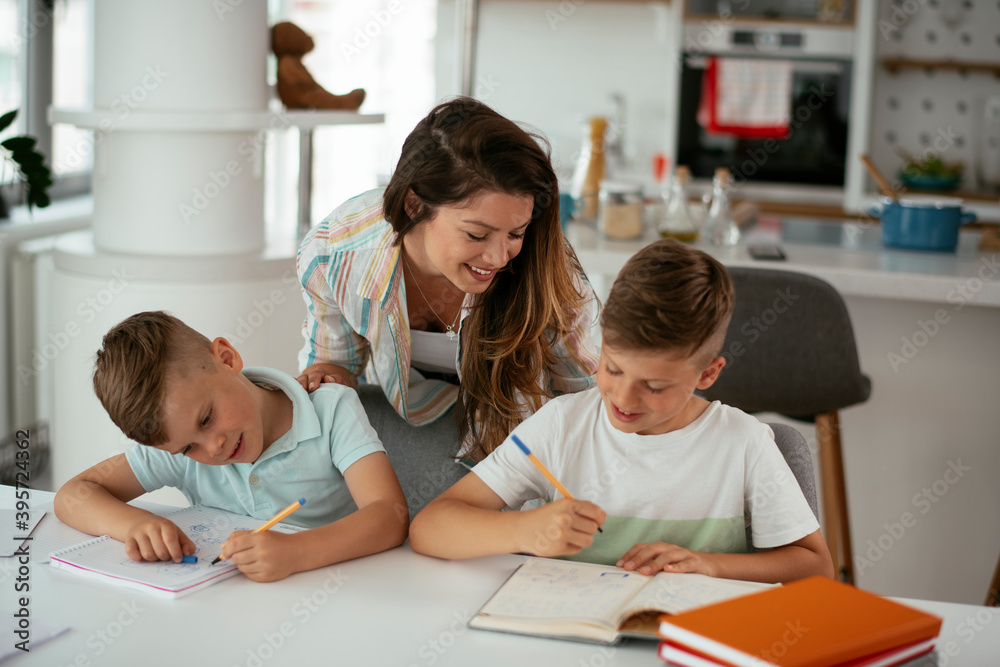 Mother helping her son with homework at home. Little boy learning at home... Mother helping her son with homework at home. Little boy learning at home...