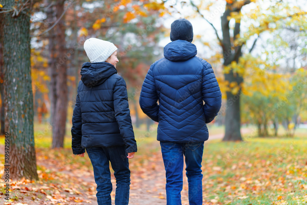 teen girl and boy walking through the park and enjoys autumn, beautiful nature with yellow leaves teen girl and boy walking through the park and enjoys autumn, beautiful nature with yellow leaves
