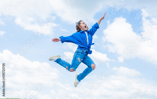 Add some action to your life. happy kid on sky background. cheerful retro girl. child having fun. happy childhood. enjoy good weather forecast. girl wearing casual style clothes. spring fashion wear