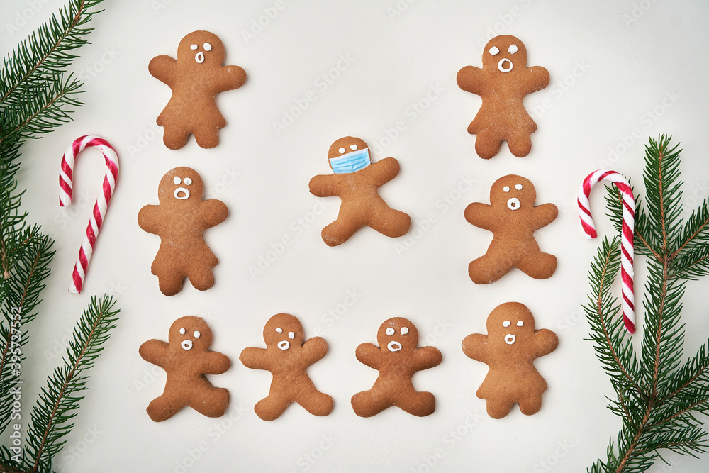Top view of gingerbread man and one with face masks Top view of gingerbread man and one with face masks