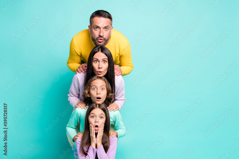 Photo portrait of big family shocked stacking heads on top of each other isolated on vivid turquoise colored background