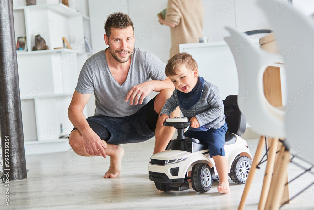 Obraz premium Child drives a push car at home as a children's vehicle