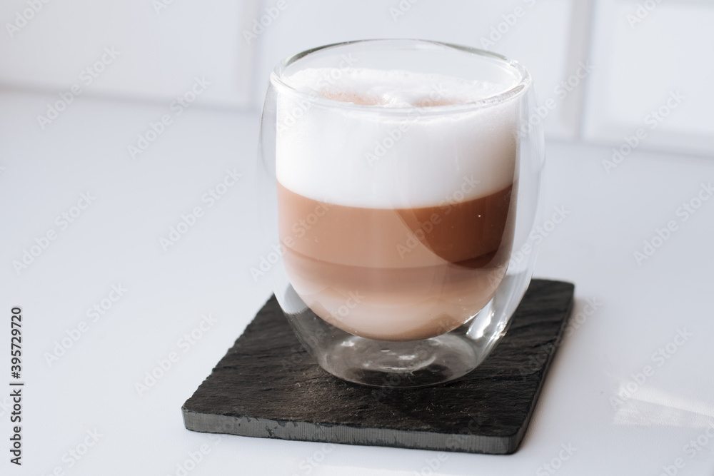 Cappuccino coffee in a double glass on a black slate board Cappuccino coffee in a double glass on a black slate board