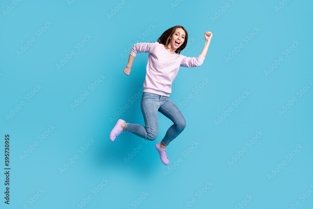 Full size photo of excited active girl jump enjoy spring season discount wear violet purple pullover isolated over blue color background Full size photo of excited active girl jump enjoy spring season discount wear violet purple pullover isolated over blue color background