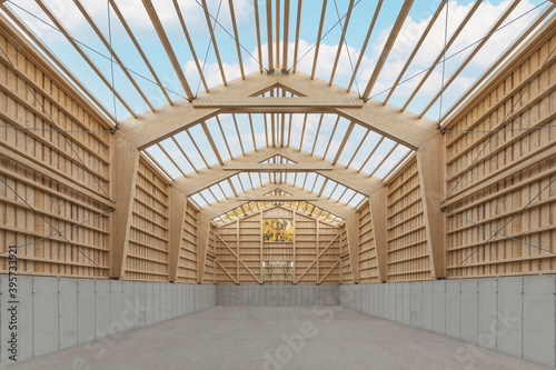 Interior of a large agricultural wooden hall during construction with an open roof