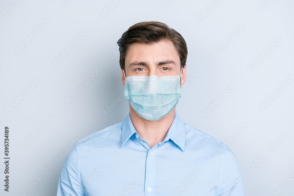 Close-up portrait of nice content guy wearing safety gauze mask influenza risk prevention isolated on gray color background Close-up portrait of nice content guy wearing safety gauze mask influenza risk prevention isolated on gray color background