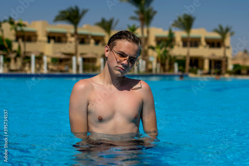 Real people concept, beautiful young man, teenage boy swimming and having fun in pool in vacation. happiness and nice body for enjoyed people live an alternative lifestyle as vacation