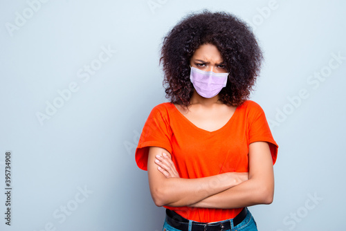 Portrait of pretty gloomy sick wavy-haired girl wearing safety mask folded arms pandemia risk group isolated on grey color background