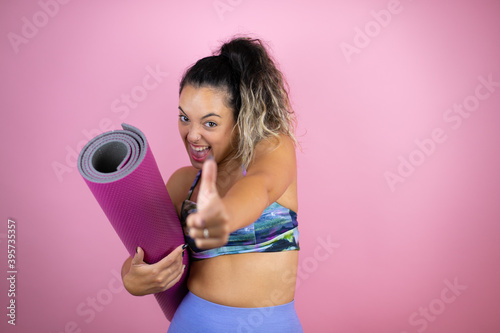 Young beautiful woman wearing sportswear and holding a splinter over isolated pink background