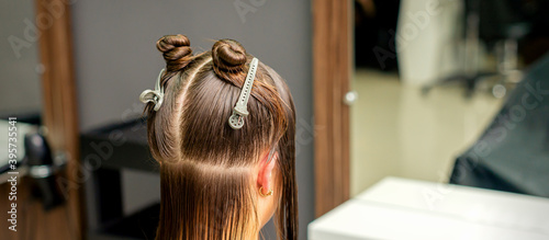 Divided women's hair into sections with clips in the barbershop