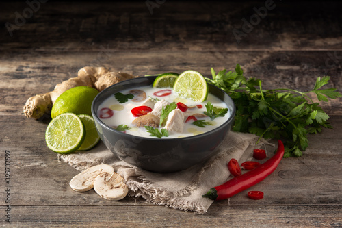 Traditional Thai food Tom Kha Gai in bowl on wooden table photo