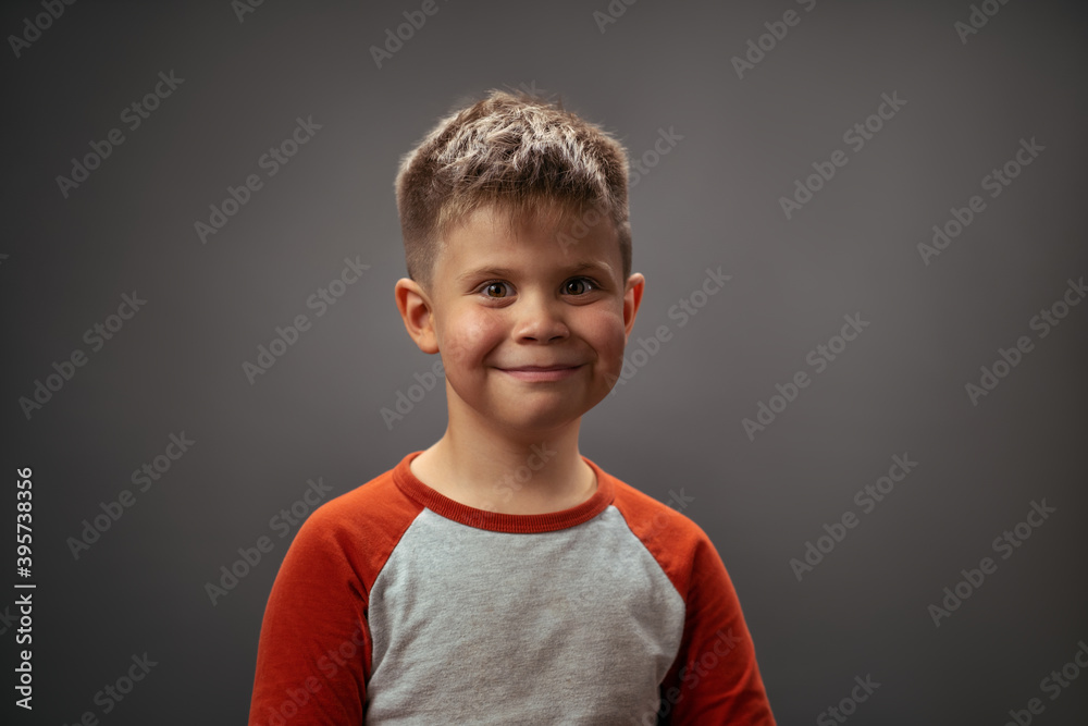 Toddler boy posing adorable cute portrait. Smiling little boy full of happy feelings. Portrait, isolated over grey background. Facial expressions, emotions, feelings. Toddler boy posing adorable cute portrait. Smiling little boy full of happy feelings. Portrait, isolated over grey background. Facial expressions, emotions, feelings.