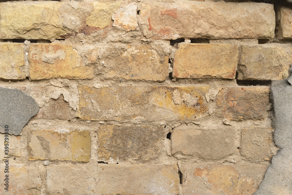 Texture of outer brick wall with old fallen cladding. Old building with falling off plaster. Background of brick wall pattern. Texture of outer brick wall with old fallen cladding. Old building with falling off plaster. Background of brick wall pattern.