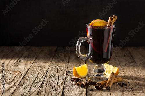 Photos Traditional mulled wine with spices on rustic wooden table