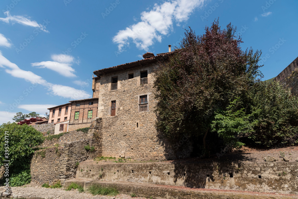 Old buildings and trees in Potes, Cantabria, Spain against the blue sky