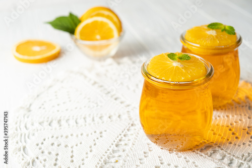Sweet dessert jelly pudding with orange citrus in glass jar on white background