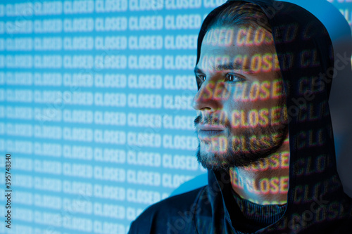 Portrait of guy on blue neon light digital interface background. Young man with beard. Digital art. Projector light illumination on face. photo