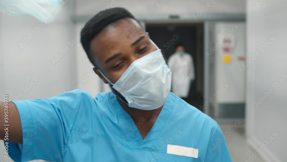 Portrait of smiling african american nurse at work walking in corridor at hospital Portrait of smiling african american nurse at work walking in corridor at hospital
