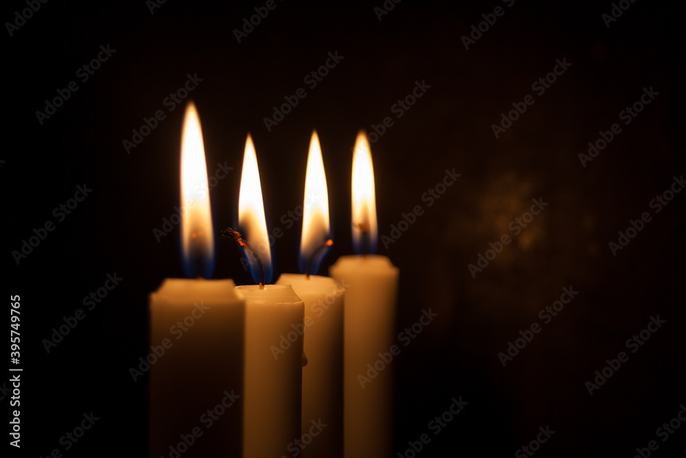 Four candles in a row burning with flame Four candles in a row burning with flame