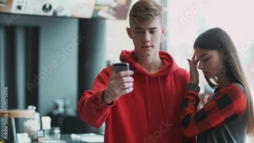 Young people take selfie with sad faces in a cafe