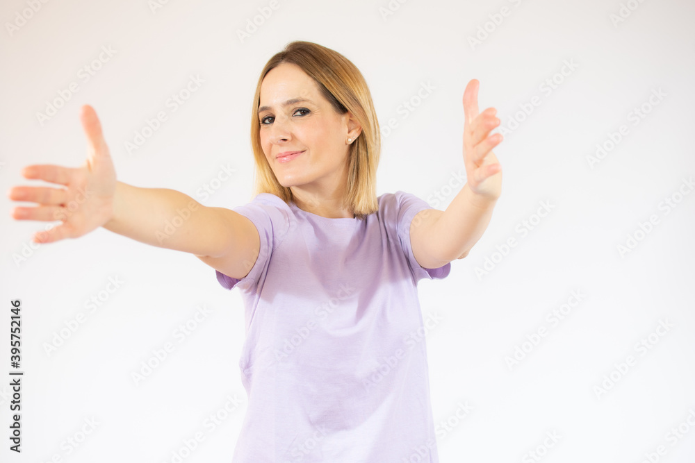 Young beautiful woman wearing casual t-shirt standing over white background smiling cheerful offering hands giving assistance and acceptance. Young beautiful woman wearing casual t-shirt standing over white background smiling cheerful offering hands giving assistance and acceptance.